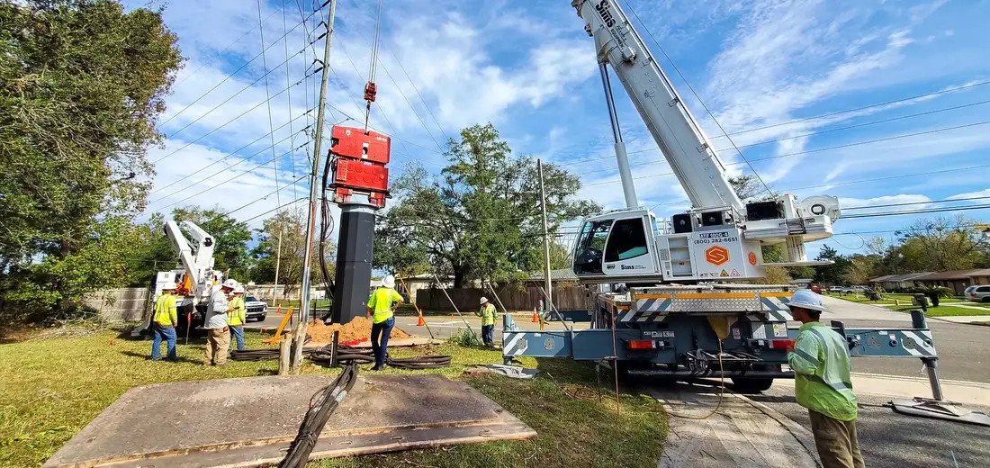 Crane crew setting a caisson at a transmission line site
