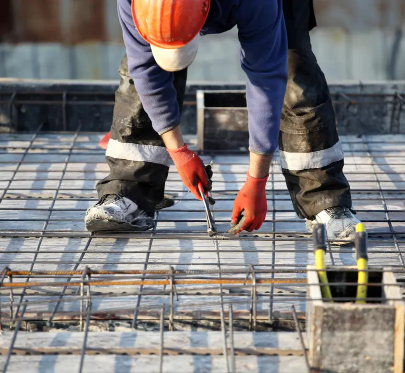 Crew tying rebar on a concrete foundation deck
