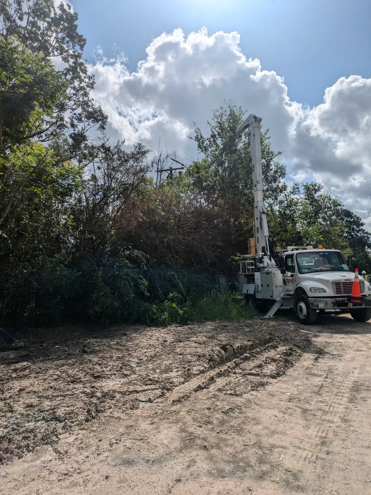 SPE bucket truck working a cleared right-of-way during storm restoration